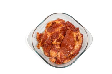 Cam bir güveçte marine edilmiş domuz eti manzarası. Parçalar birbirine sıkıca bağlanmış..