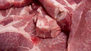 Birkaç çiğ domuz pirzolası sıkıca üst üste dizilir. Sulu dokusu yavaşça döner ve farklı kesik yüzeyler ortaya çıkar..