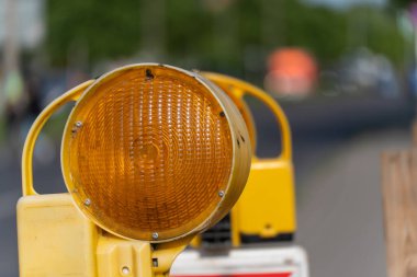 Sarı bir uyarı ışığı bir inşaat alanını aydınlatır. Işık, yol trafiği için uyarı işareti..