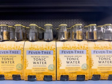 Almanya 7 Haziran 2025. Süpermarketin rafında sıra sıra Ateş Ağacı Premium Hint Toniği şişeleri var. Zarif cam şişeler dört paket sarı paketlerde mevcuttur..