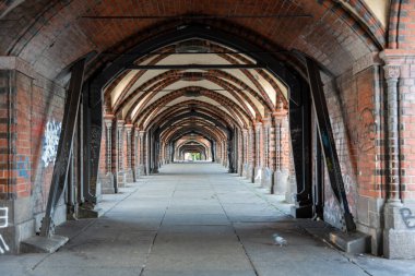 Kırmızı tuğla kemerli uzun bir geçit simetrik olarak mesafeye kadar uzanıyor. Oberbaum Köprüsü 'nün ünlü köprü mahzeni şehir gübresi bakımından zengindir..