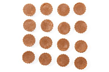 Şekerleme Kupaları Üst Görünüm Beyaz Arkaplan. 16 yuvarlak şekerlemeden oluşan düz bir düzenleme. Tatlılar yukarıdan çekiliyor ve beyaz arka planda izole ediliyor..