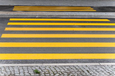 Sarı yayalar, asfalt üzerinde açık çizgilerle zebra geçiyorlar. Odak noktası grafik yapısı..