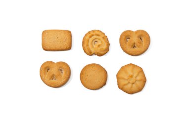 Danimarka kurabiyelerinin altı farklı şekli iki sıra halinde düzenlenir ve yukarıdan çekilir. Her kurabiye kahverengidir ve beyaz arka planda izole edilmiştir..