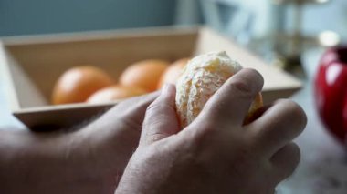 Turuncu Yakın plan Soyma. Eller olgun bir portakalı dikkatlice soyar ve içindeki taze narenciyi ortaya çıkarır. Ayrıntılı yakın çekim vurguları dokusu ve rengi.