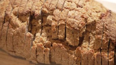 Dilimlenmiş ekmeğin yukarıdan görünüşü. Kameranın altında dönen kabuklu ekmek, altın dilimleri ve zanaatkar dokusunu ortaya çıkarıyor. Fırın ve yemek sahneleri için harika..