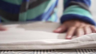 Kumaş kenarı desenli bir ütü masasında kaldırıldı. Yumuşak kıvrımlar ve doku ayrıntılı olarak görülebilir..