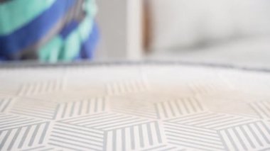 Demir kenar boyunca hareket ederken bir el gri kumaşı sabitler. Kırışıklıklar ısı ve buharla düzeltilir..