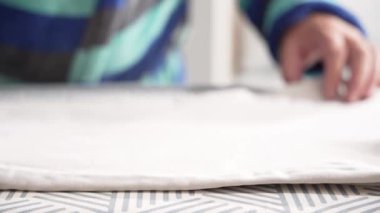 Ütü masasına beyaz bir giysi bastıran buharlı ütünün yakın çekimi. Kumaş düz ve pürüzsüz.