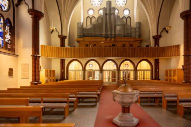 Güverteye tahta banklar ve galeride büyük bir organla bakın. Ilık ışık odayı aydınlatır..