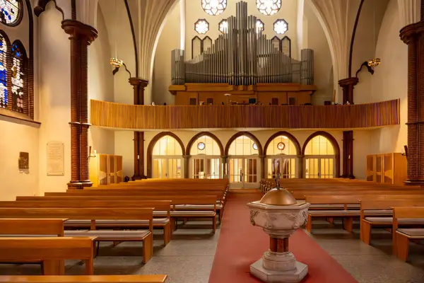 Güverteye tahta banklar ve galeride büyük bir organla bakın. Ilık ışık odayı aydınlatır..