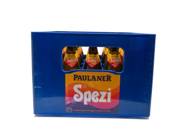 Almanya 28 Ağustos 2025. Sandık Önü Görünümü. Spezi şişeleriyle dolu mavi bir Paulaner sandığı, kola-portakallı soda. Etikette Spezi parlak turuncu ve pembe renklerle vurgulanıyor.