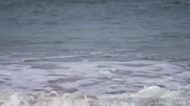 Dalgalar daha güçlü görünür ve deniz daha koyu renklidir. Daha canlı bir dalga deseni görünür..