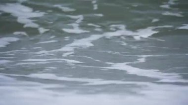 Kırılma dalgasına yakın çekim. Bir dalga güçlü bir şekilde kırılır ve beyaz köpüğe sıçrar. Su dinamik bir şekilde akıyor..