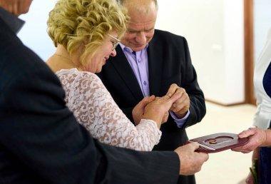 Evlendikleri gün yaşlı bir çift. Mutlu gülümseyen adam karısının parmağına yüzük takar..