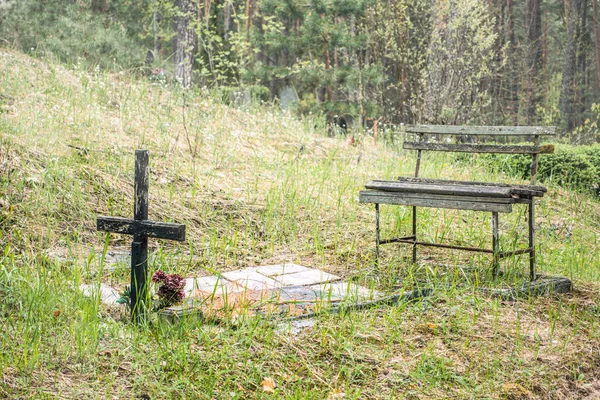 墓地で古い風化した木製の十字架とベンチと放棄された墓 人はいない — ストック写真