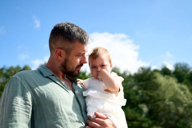 Güneşli sahilde kızını taşıyan mutlu bir baba. Baltık Denizi, Letonya