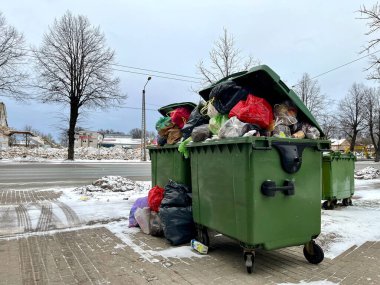 Riga, Letonya - 4 Ocak 2024: Çöp tenekeleri çöp, çöp ve poşetlerle dolup taşıyor. Çevre kirliliği.