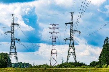 Bulutlu bir gökyüzü ve kırsal kesimde uzanan elektrik iletim hatlarının görüntüsü