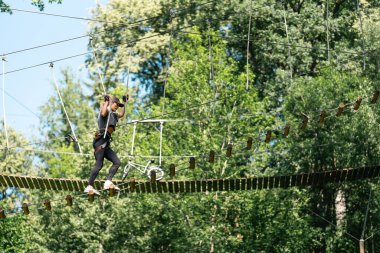 Canlı ve yemyeşil ağaçların arasına kurulmuş heyecan verici yüksek ipli bir macera yaşayın.