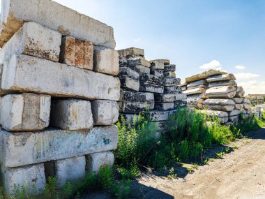Beton bloklar açık bir gökyüzünün altındaki inşaat alanında düzenli bir şekilde istiflenir.