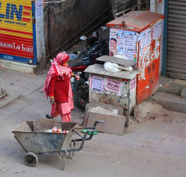Delhi India 2023年 ピンクサリを身に着けている伝統的なラジャスタニの女性 仕事で ほうきとスチールハンドトラックで洗浄器具を運ぶ — ストック写真