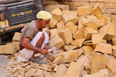 JAISALMER RAJASTHAN INDIA - 02 13 2023: tanımlanamayan adam bir kumtaşı parçası üzerinde çalışıyor