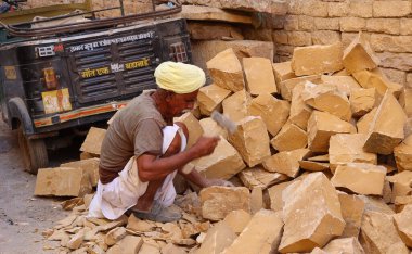 JAISALMER RAJASTHAN INDIA - 02 13 2023: tanımlanamayan adam bir kumtaşı parçası üzerinde çalışıyor