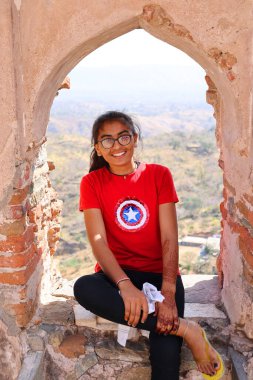 KUKMBHALGARH RAJASTHAN INDIA - 02 23 2023: Kumbhal kalesini ziyaret eden genç kız. Hindistan 'ın büyük nüfusunun arkasındaki en büyük faktör ülkenin neredeyse yarısı kadar genç Hintli.