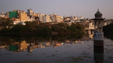 UDAIPUR RAJASTHAN INDIA - 02 20 2023: Pichola Gölü kıyısı boyunca yapılar. Pichola Gölü, 1362 yılında oluşturulan yapay bir tatlı su gölüdür..