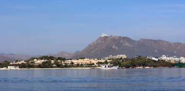UDAIPUR RAJASTHAN INDIA - 02 20 2023: Pichola Gölü kıyısı boyunca yapılar. Pichola Gölü, 1362 yılında oluşturulan yapay bir tatlı su gölüdür..