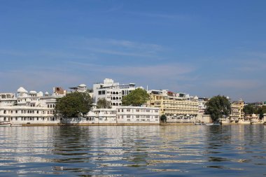 UDAIPUR RAJASTHAN INDIA - 02 20 2023: Pichola Gölü kıyısı boyunca yapılar. Pichola Gölü, 1362 yılında oluşturulan yapay bir tatlı su gölüdür..