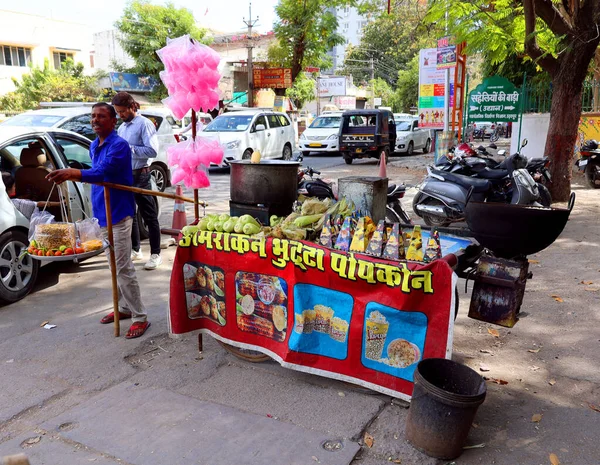 JODHPUR RAJASTHAN INDIA - 02 13 2023: adam tatlı mısır ve pamuk şeker satıyor