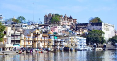 UDAIPUR RAJASTHAN INDIA - 02 20 2023: Pichola Gölü kıyısı boyunca yapılar. Pichola Gölü, 1362 yılında oluşturulan yapay bir tatlı su gölüdür..
