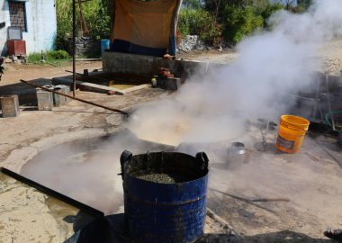 RURAL RAJASTHAN Hindistan - 02 16 2023: Kaynar şeker kamışı fabrikasında çalışan adam