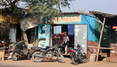 RURAL RAJASTHAN INDIA - 02: 15 2023: Berber dükkanında sakal tıraşı olan kimliği belirsiz bir adam.
