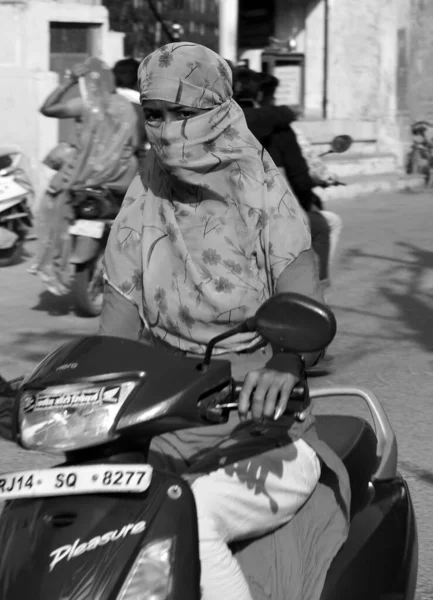 stock image BUNDI RAJASTHAN INDIA - 02 17 2023: A female riding scooter covered her face and head.