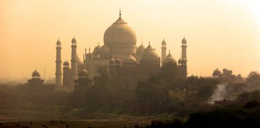 TAJ MAHAL UTTAR PRADESH INDIA - 03 01 2023: Günbatımında Taj Mahal manzarası Agra 'da Yamuna nehrinin sağ kıyısında bir fildişi-beyaz mermer mozoledir.