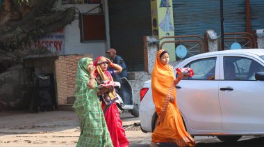 AGRA UTTAR PRADESH Hindistanı - 03 01 2023: Renkli peçeli ve sarili Hintli kadınlar