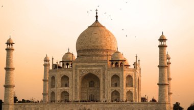 TAJ MAHAL UTTAR PRADESH INDIA - 03 01 2023: Günbatımında Taj Mahal manzarası Agra 'da Yamuna nehrinin sağ kıyısında bir fildişi-beyaz mermer mozoledir.