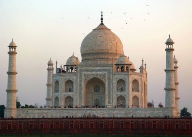 TAJ MAHAL UTTAR PRADESH INDIA - 03 01 2023: Günbatımında Taj Mahal manzarası Agra 'da Yamuna nehrinin sağ kıyısında bir fildişi-beyaz mermer mozoledir.
