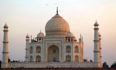 TAJ MAHAL UTTAR PRADESH INDIA - 03 01 2023: Günbatımında Taj Mahal manzarası Agra 'da Yamuna nehrinin sağ kıyısında bir fildişi-beyaz mermer mozoledir.