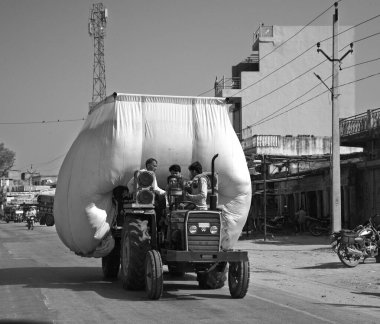 RURAL RAJASTHAN Hindistan - 02 23 2023: Traktör saman taşıyor ve yolda ilerliyor.