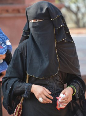 FATEHPUR SIKRI INDIA - 03 01 2023: Peçeli kadın ve siyah ceketli adam Fatehpur Sikri, Hindistan 'ın Uttar Pradesh ilçesinde yer alan bir kasabadır..