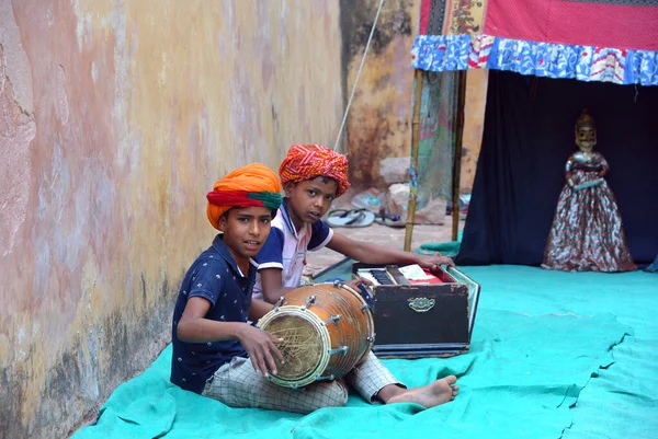 stock image JAIPUR RAJASTHAN INDIA - 04 01 2023: Rajasthani children music artist in traditional dress, playing tamtam at the exit of the city palace