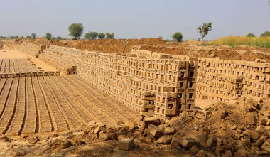 UTTAR PRADESH INDIA - 03 01 2023: Ham tuğla kurutmak için istiflenmiş. Tuğla fabrikasında tuğlalar. Hindistan 'da geleneksel kil tuğla üretimi.