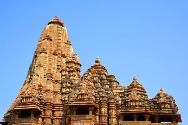 KHAJURAHO INDIA MADYHA PRADESH - 03 2023: Khajuraho Anıtlar Grubu, nagara tarzı mimari sembolizmleri ve birkaç erotik heykelleriyle ünlü Hindu ve Jain tapınaklarıdır.