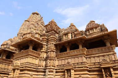 KHAJURAHO INDIA MADYHA PRADESH - 03 2023: Khajuraho Anıtlar Grubu, nagara tarzı mimari sembolizmleri ve birkaç erotik heykelleriyle ünlü Hindu ve Jain tapınaklarıdır.
