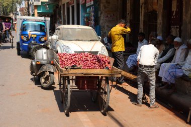 VARANASI BHOJPUR PURVANCHAL INDIA - 03 05 2023: Varanasi Hindistan 'daki eski pazarda kırmızı soğan satan satıcılar. Varanasi, Ganj Nehri 'nin kutsal sularında yıkanan Hindu hacıları çekiyor.