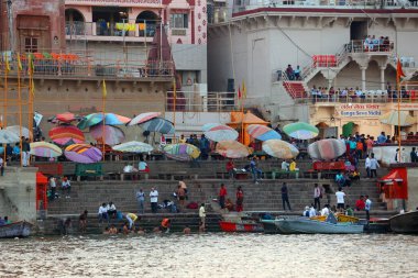 VARANASI BHOJPUR PURVANCHAL INDIA - 03 05 2023: Arati 'nin kutsal dini töreni. İnsanlar, Ganj nehrinin kıyısındaki Dashashwamedh Ghat 'ta dua ederek ve dini bir eylem izleyerek oturur.